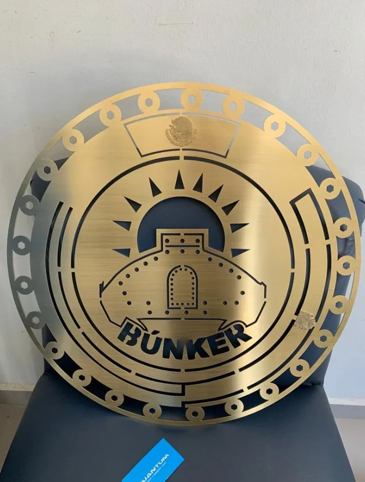 Placa circular de latón con logotipo calado