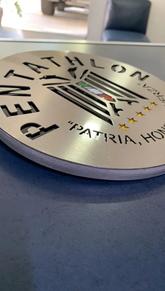 Placa circular de acero con logotipo y texto calados