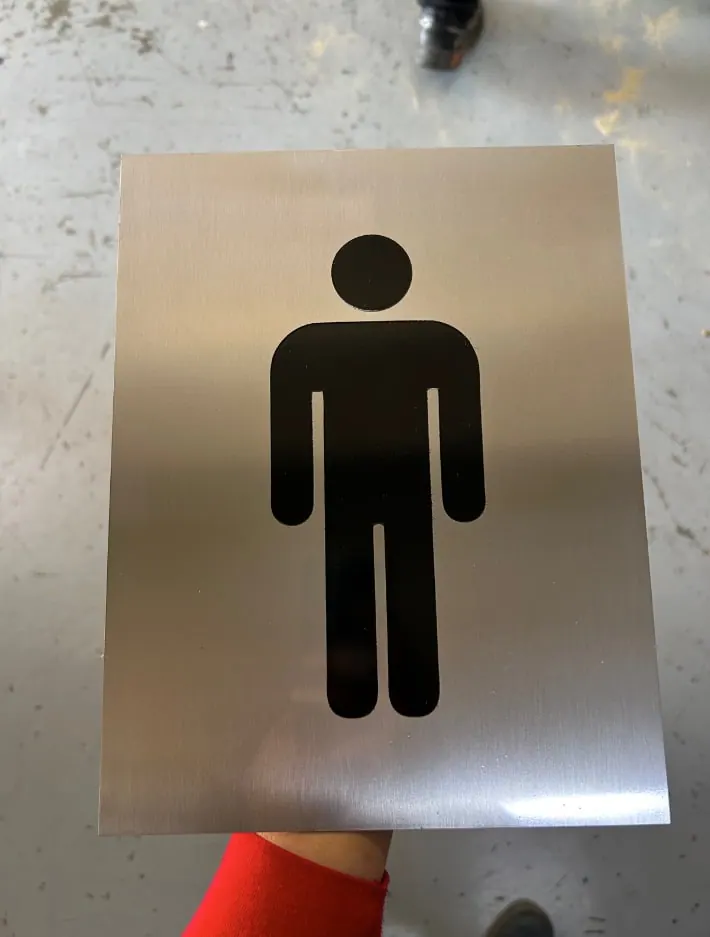 Placa de acero cepillado con pictograma de sanitario de hombres