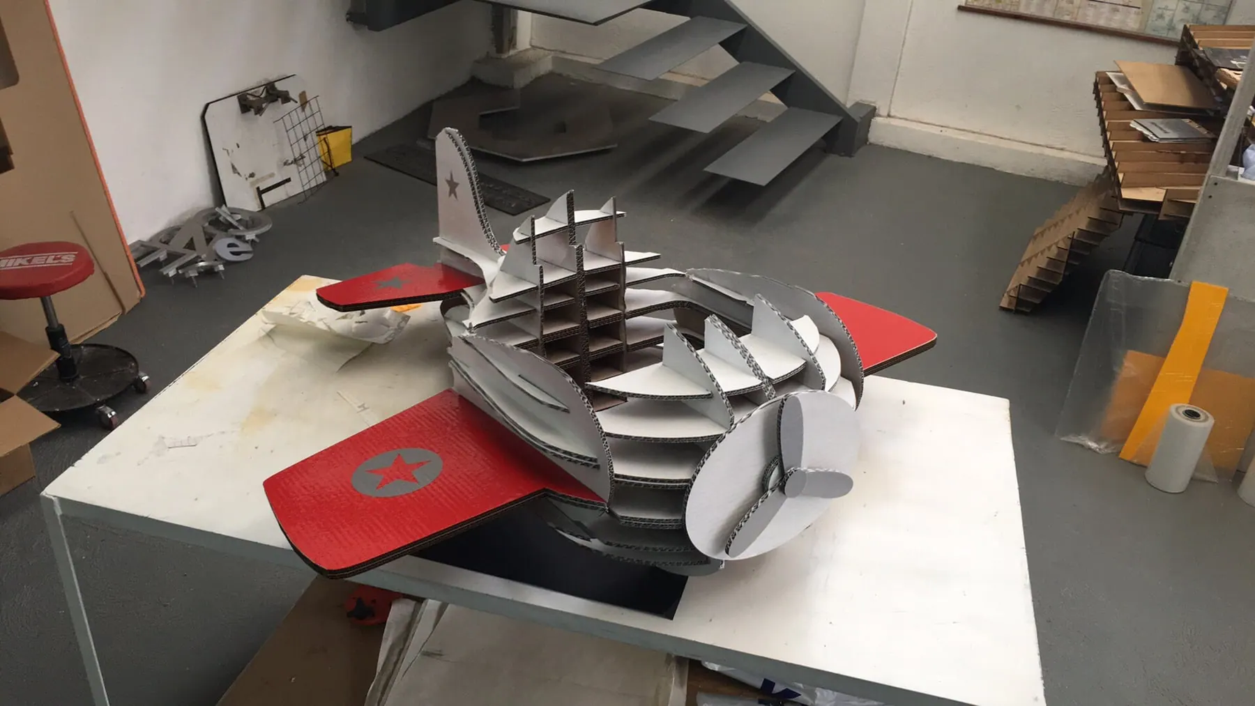 Maqueta de avión armada con piezas de cartón corrugado cortadas con láser, en el taller