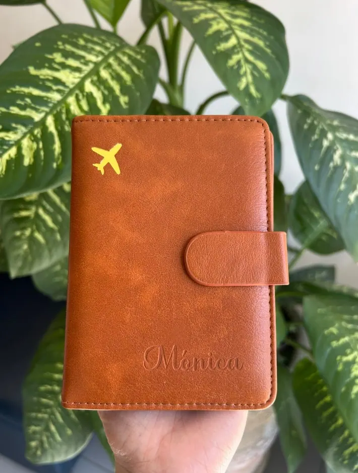 Porta pasaporte de vinipiel café con un nombre grabado