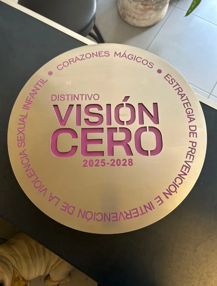 Distintivo circular con texto grabado y calado en rosa